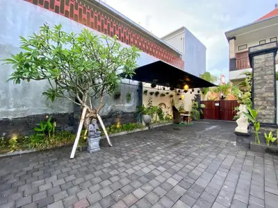 a tree in a courtyard with a building at Dikubu Belong Seminyak in Seminyak