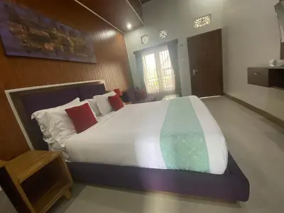 a bedroom with a large white bed with red pillows at Dikubu Belong Seminyak in Seminyak