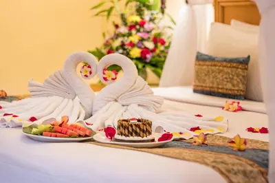 two white swans sitting next to a plate of food at Legian Paradiso Hotel in Legian