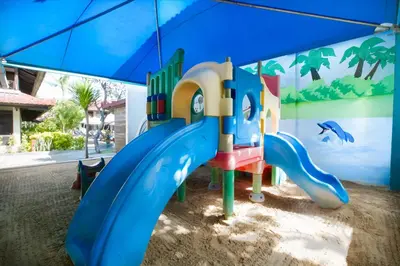 a playground in the sand under an umbrella at Legian Paradiso Hotel in Legian