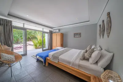 a bedroom with a bed and a large window at Villa Nahema - 4BR Villa in Seminyak Next to the Beach in Canggu