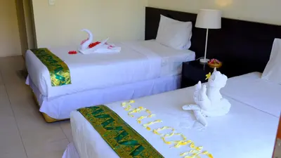 a hotel room with two beds with white sheets at Kubu Green in Nusa Dua