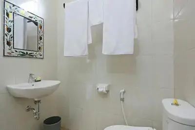 a white bathroom with a sink and a toilet at Kubu Green in Nusa Dua