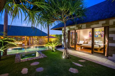 a backyard with a swimming pool and a house at Rachline Villa in Kerobokan