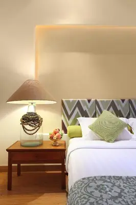a bedroom with two beds and a lamp on a table at Bali Mandira Beach Resort & Spa in Legian