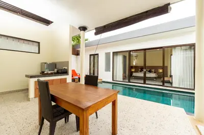 a dining room with a table and a swimming pool at Jay's Villa Umalas in Canggu