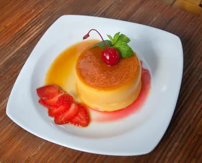 a white plate with pancakes and strawberries on a table at Jay's Villa Umalas in Canggu