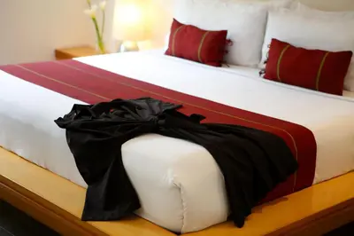 a large bed with a black dress on it at Bali Island Villas and Spa Seminyak in Seminyak