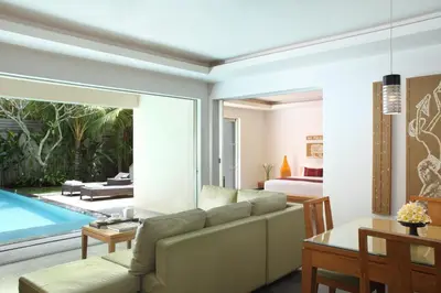 a living room with a couch and a swimming pool at Bali Island Villas and Spa Seminyak in Seminyak