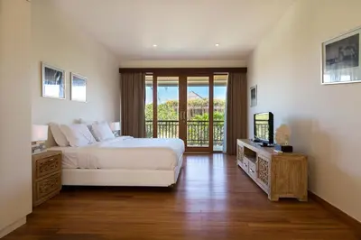 a bedroom with a bed and a television and a balcony at Dream villa Seminyak in Seminyak