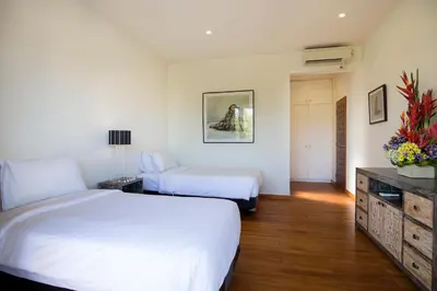 a hotel room with two beds and a dresser at Dream villa Seminyak in Seminyak