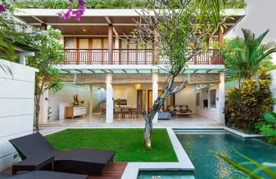 a house with a pool and a tree in the yard at Dream villa Seminyak in Seminyak