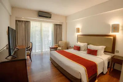 a hotel room with a bed and a television at Kuta Paradiso Hotel in Kuta