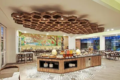 a restaurant with tables and chairs and a large ceiling at Wyndham Garden Kuta Beach Bali in Kuta