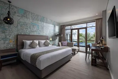 a hotel room with a bed and a desk and a bedroom at Wyndham Garden Kuta Beach Bali in Kuta