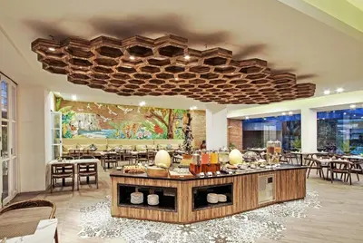 a restaurant with tables and chairs and a large ceiling at Wyndham Garden Kuta Beach Bali in Kuta