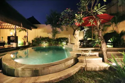 a swimming pool in a backyard at night at The Sanyas Suite Bali in Seminyak
