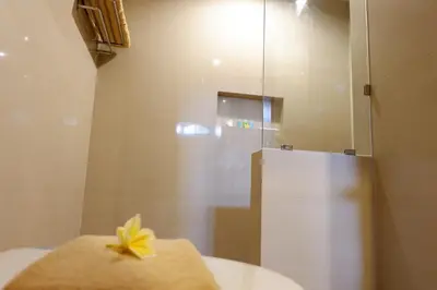 a bathroom with a shower with a towel on the sink at Seminyak Paradiso Hotel in Seminyak