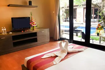 a room with a bed with a swan sitting on it at Sindhu Mertha Suite in Sanur
