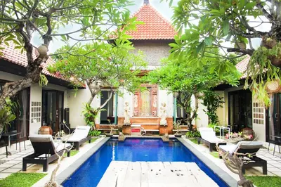 a swimming pool in the backyard of a house at Sindhu Mertha Suite in Sanur
