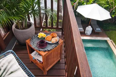 a tray of food on a table next to a pool at 3BR Villa Erja - Minggu Villas - Special Stay Bonus in Kerobokan