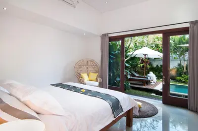 a bedroom with a bed and a view of a pool at 3BR Villa Erja - Minggu Villas - Special Stay Bonus in Kerobokan