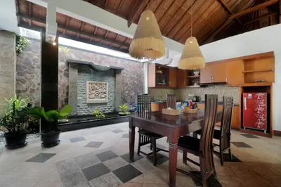 a kitchen and dining room with a wooden table and chairs at Singgah Villas Seminyak in Seminyak