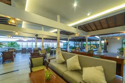 a living room with a couch and tables and chairs at Nirmala Hotel Jimbaran in Jimbaran