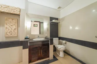 a bathroom with a toilet and a sink at Nirmala Hotel Jimbaran in Jimbaran