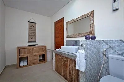 a bathroom with a sink and a toilet and a mirror at Rumah Indah Villa in Seminyak
