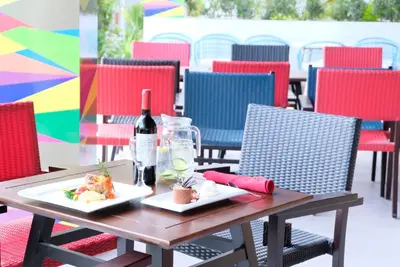 a table with two plates of food and a bottle of wine at Kuta Beach Club Hotel in Kuta