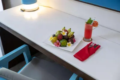 a plate of fruit and a drink on a table at Kuta Beach Club Hotel in Kuta