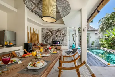 a dining room with a table and a swimming pool at Villa Safari in Seminyak