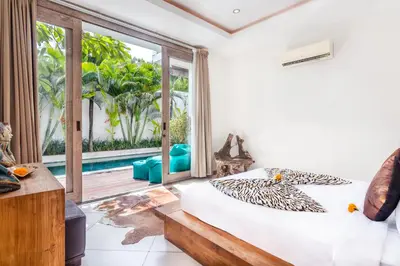 a bedroom with a bed and a large window at Villa Safari in Seminyak