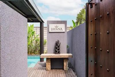 a bench sitting on a porch next to a pool at Javana Royal Villas in Seminyak