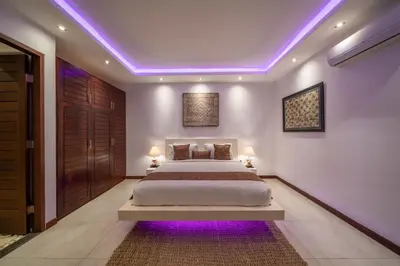 a bedroom with a bed with purple lights on the ceiling at Villa Tira - Elegant 3BR in Central Seminyak in Seminyak