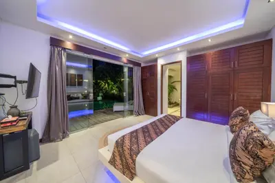 a bedroom with a large bed and a large window at Villa Tira - Elegant 3BR in Central Seminyak in Seminyak