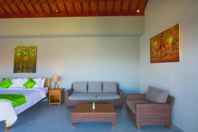 a living room with a bed and a couch and a table at Sun Shoot Villas Seminyak in Seminyak