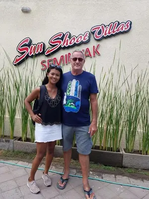a man and a woman standing in front of a sign at Sun Shoot Villas Seminyak in Seminyak
