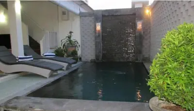 a swimming pool in the middle of a house with water at Sun Shoot Villas Seminyak in Seminyak