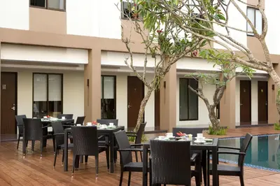 a group of tables and chairs in a courtyard at Hotel Santika Kuta in Kuta