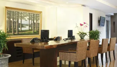 a conference room with a wooden table and chairs at Hotel Santika Kuta in Kuta