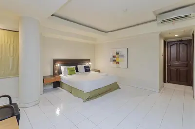a bedroom with a large bed in a room at Urbanview Hotel Taman Suci Denpasar Bali in Denpasar