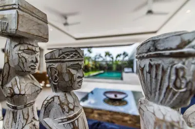a pair of carved wooden statues in a living room at Villa Juna - Beautiful 3 Bedroom in Seminyak in Seminyak