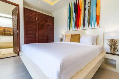 a bedroom with a large white bed and a bathroom at Villa Nala - Amazing 3-Bedroom in Seminyak in Seminyak