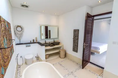 a bathroom with a tub and a sink and a mirror at Villa Saha - Elegant 3-Bedroom in Seminyak in Seminyak