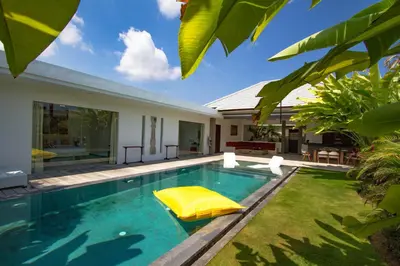 a swimming pool with a yellow float in front of a house at Villa Saha - Elegant 3-Bedroom in Seminyak in Seminyak