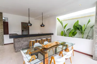 a dining room with a glass table and chairs at Villa Saha - Elegant 3-Bedroom in Seminyak in Seminyak