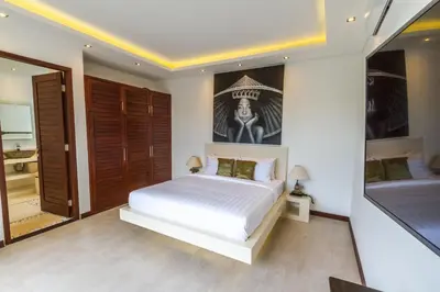 a bedroom with a white bed and a bathroom at Villa Saha - Elegant 3-Bedroom in Seminyak in Seminyak