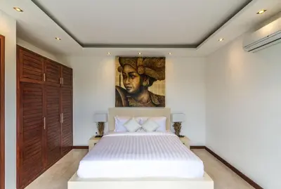 a bedroom with a bed with a painting on the wall at Villa Saha - Elegant 3-Bedroom in Seminyak in Seminyak